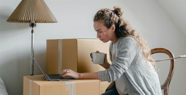 people on their computers surrounded by moving boxes