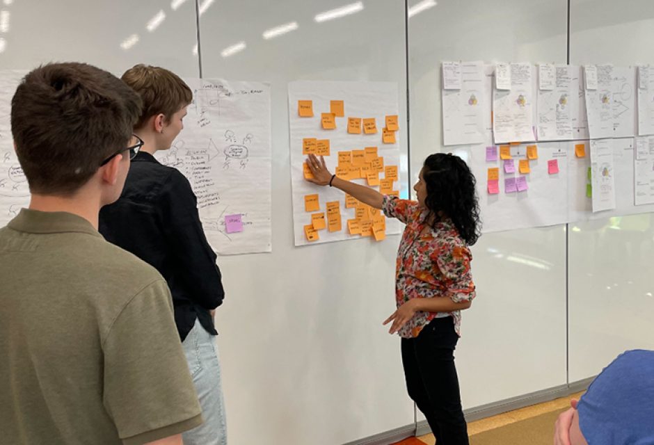 Meghana at a vision workshop with concepts on the board